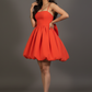 Woman wearing a red dress posing against a gray background