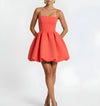 Woman wearing a coral dress on a white background