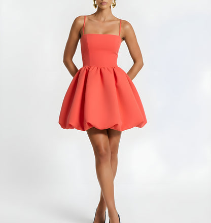 Woman wearing a coral dress on a white background